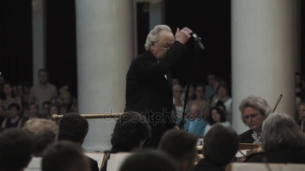 Sint-Petersburg, Rusland - 23 juni 2016: Wit-haired kapelmeester regisseren viool orkest in klassieke concertzaal — Stockvideo