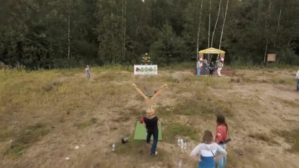 Sankt Petersburg, Ryssland - 30 juli 2016: antenn. Kvinna skjuta plushy med slangbella på pyramid block på kanten av skogen — Stockvideo