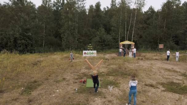 Sankt Petersburg, Ryssland - 30 juli 2016: Aerial skott kvinna som spelar irl arga fåglar med gigantisk slangbella på kanten av skogen — Stockvideo