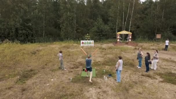 SAINT PETERSBURG, RUSSIE - 30 JUILLET 2016 : Vue aérienne d'un homme abattant des peluches avec une fronde géante en bordure de forêt — Video