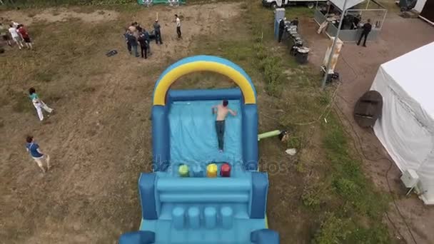 SAN PETERSBURG, RUSIA - 30 DE JULIO DE 2016: Arriba aérea dos hombres atravesando la pista de obstáculos inflable azul sobre arena — Vídeos de Stock