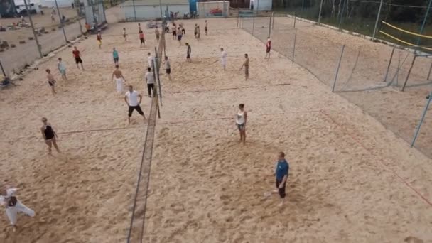 СЕНТ-ПЕТЕРБУРГ, РОССИЯ - 30 июля 2016 г.: Вид с воздуха на людей, играющих в пляжный бадминтон на песчаной площадке в солнечный день — стоковое видео