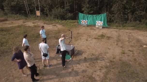 SAN PETERSBURG, RUSIA - 30 DE JULIO DE 2016: Vista aérea del hombre disparando flechas de arco en diana en el borde del bosque en verano — Vídeo de stock