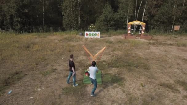 SAN PETERSBURG, RUSIA - 30 DE JULIO DE 2016: Hombres de vista aérea jugando un juego de honda gigante derribando plushies afuera — Vídeo de stock