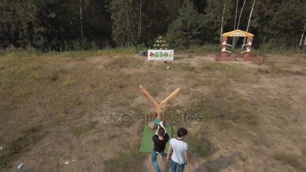 SAN PETERSBURG, RUSIA - 30 DE JULIO DE 2016: Vista aérea de dos hombres jugando un juego de honda gigante derribando plushies afuera — Vídeos de Stock