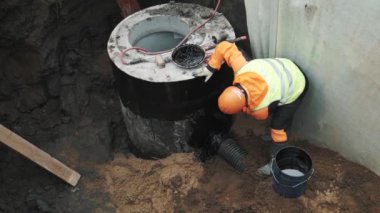 Saint Petersburg, Rusya - 26 Eylül 2016: Siyah zift beton odası kuyu halkada uygulama turuncu baret işçi