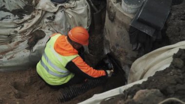 Saint Petersburg, Rusya - 26 Eylül 2016: Siyah zift beton odası kuyu halkada uygulama turuncu baret Builder'da