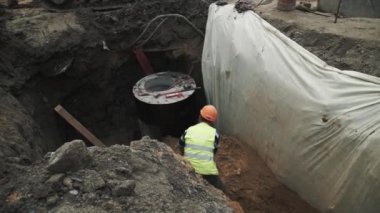 Saint Petersburg, Rusya - 26 Eylül 2016: Turuncu baret beton odası kuyu halkası üzerinde kuma gömme içinde alt