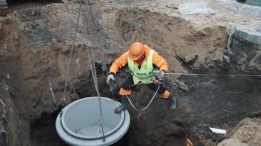 Saint Petersburg, Rusya Federasyonu - 26 Eylül 2016: İşçisi kask bir hükümdar ile beton kuyu halka zincir üzerinde asılı duruyor