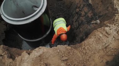 Saint Petersburg, Rusya - 26 Eylül 2016: İşçisi kask Kepçe su ile kova beton odası kuyu halka etrafında