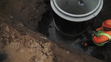 Saint Petersburg, Rusya Federasyonu - 26 Eylül 2016: Çimento ile işçi kask dikiş iki beton odası kuyu halkalar