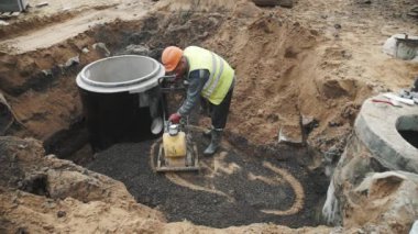 Saint Petersburg, Rusya - 26 Eylül 2016: Builder kullanım plaka Kompaktör makadam beton kuyu yüzüklü siperde üzerinde