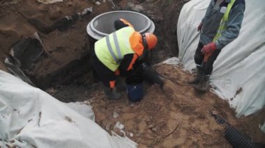 Saint Petersburg, Rusya - 26 Eylül 2016: Siyah zift beton odası kuyu halkada bulaşması turuncu baret Builder'da