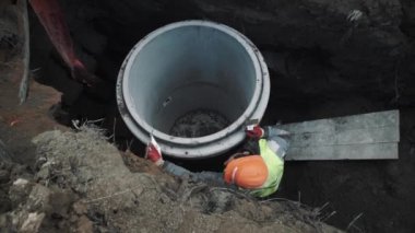 Saint Petersburg, Rusya Federasyonu - 26 Eylül 2016: Baret işçi uygulamak beyaz beton odası kuyu yüzük hendekte kenarında