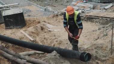 Saint Petersburg, Rusya - 26 Eylül 2016: Slowmotion işçisi kask ölçü uzun siyah plastik boru ile şerit metre