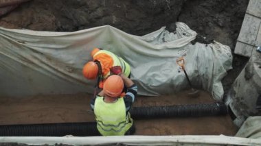 Saint Petersburg, Rusya Federasyonu - 26 Eylül 2016: İşçisi kask hendekte kızak çekiç ile uzun plastik boru yendi