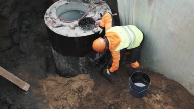 Saint Petersburg, Rusya - 26 Eylül 2016: İşçisi kask plastik tüp beton odası kuyu ringde tar uygulayarak
