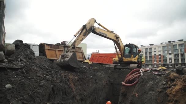 SAINT PETERSBURG, RUSSIA - SEPTEMBER 26, 2016: Dolly shot slowmotion excavator draw soil from ditch at building site — Stock Video