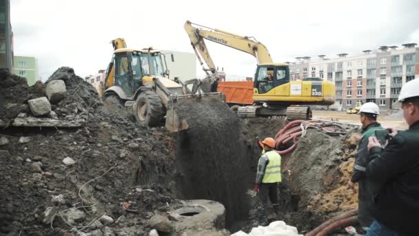 Sankt Petersburg, Ryssland - 26 September 2016: Slowmotion arbetstagare film på smartphone som bulldozer dump breakstone i dike — Stockvideo