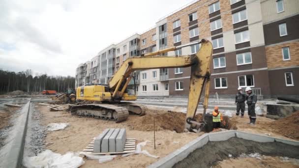 SAINT PETERSBURG, RUSSIA - SEPTEMBER 26, 2016: Slowmotion yellow excavator digging soil in ditch at building site — Stock Video