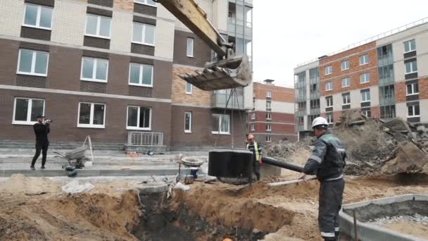 SAN PETERSBURG, RUSIA - 26 DE SEPTIEMBRE DE 2016: Anillo de alcantarilla de hormigón en cámara lenta balanceándose en cucharón de excavadora en obra — Vídeos de Stock