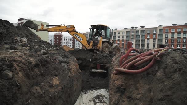 SAINT PETERSBURG, RUSSIA - SEPTEMBER 26, 2016: Slowmotion bulldozer excavator digging down sewer ditch at building site — Stock Video