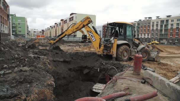 SAN PETERSBURG, RUSIA - 26 DE SEPTIEMBRE DE 2016: excavadora excavadora de cámara lenta enterrando zanja de alcantarillado en obra — Vídeos de Stock