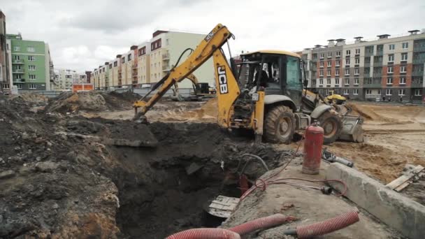 SAINT PETERSBURG, RUSSIA - SEPTEMBER 26, 2016: Slowmotion bulldozer excavator dump soil in to sewer trenche at building site — Stock Video