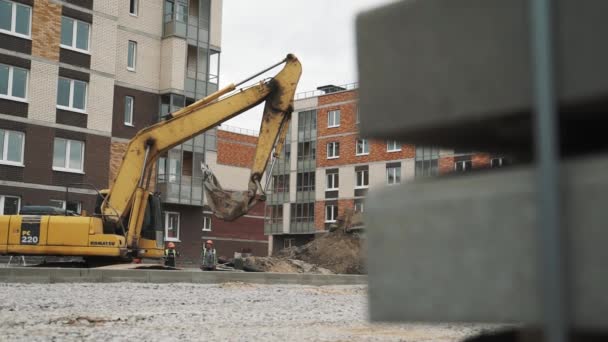 SAN PETERSBURG, RUSIA - 26 DE SEPTIEMBRE DE 2016: Excavadora excavadora Dolly con anillo de alcantarilla de hormigón en cucharón en obra — Vídeos de Stock