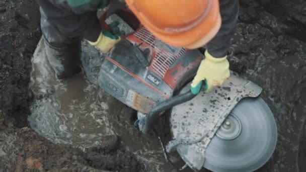 Saint Petersburg, Federacja Rosyjska - 26 września 2016: Bliska pracownika w kask wykorzystania kołowe piły na pierścienie właz komory betonowe — Wideo stockowe