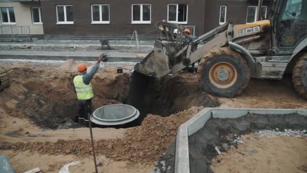 SAN PETERSBURG, RUSIA - 26 DE SEPTIEMBRE DE 2016: Los gestos de los trabajadores de cámara lenta al conductor de la excavadora arrojan macadam en la zanja — Vídeo de stock