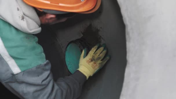 SAINT PETERSBURG, RÚSSIA - SETEMBRO 26, 2016: Close up builder in hard hat use selante em tubo de plástico immured in concrete — Vídeo de Stock