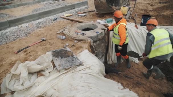 Saint Petersburg, Federacja Rosyjska - 26 września 2016: Pracownik w kask umieścić cementu na potoku podłączony do studni betonowej — Wideo stockowe