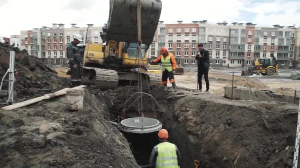 상트페테르부르크, 러시아-9 월 26 일, 2016: 콘크리트 맨홀 챔버 링 hangig 굴 삭 기 국자도 랑에서 조립에 — 비디오