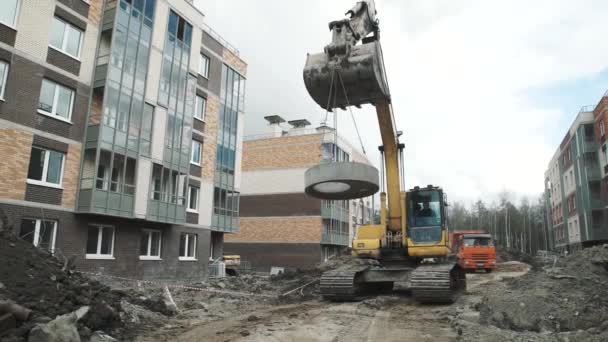 Saint Petersburg, Oroszország - szeptember 26, 2016: A sárga kotrógép beton akna gyűrű múlik láncok: építési telek. — Stock videók