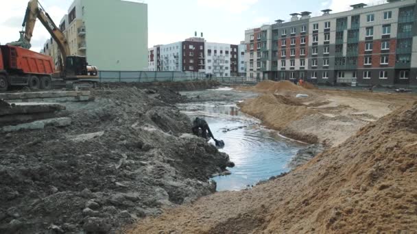 Sankt Petersburg, Ryssland - 26 September 2016: Slowmotion man rita vatten med hink från trench på byggnadsplatsen — Stockvideo