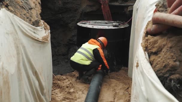 SAINT PETERSBURG, RUSSIA - 26 SETTEMBRE 2016: Lavoratore con tappo a cilindro in plastica nera con anello pozzetto in cemento fossato — Video Stock