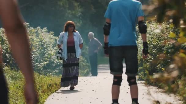 SAINT PETERSBURG, RUSSIE - 28 AOÛT 2016 : Des gens marchent dans un parc par une journée ensoleillée. Un homme sur un roller. Homme nu-haut — Video