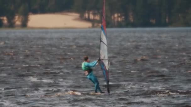 圣彼得堡，俄罗斯-2016 年 8 月 28 日︰ 蓝色泳装游乐设施中的人的全景镜头风帆冲浪在湖上高速 — 图库视频影像