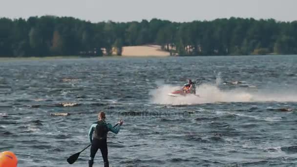 SAINT PETERSBURG, RUSSIA - AUGUST 28, 2016: Tracking shot of man and boy in life vest ride a jet ski on hight speed — Stock Video