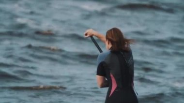 Saint Petersburg, Rusya Federasyonu - 28 Ağustos 2016: Raket kullanarak sörf tahtası sporcumuz tam mayo orta çekim sürmek