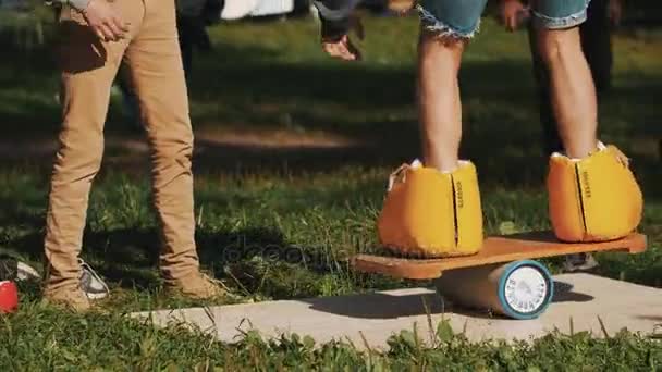 SAN PETERSBURG, RUSIA - 28 DE AGOSTO DE 2016: Un joven intenta equilibrar la tabla en un cilindro mientras usa botas gigantes — Vídeos de Stock