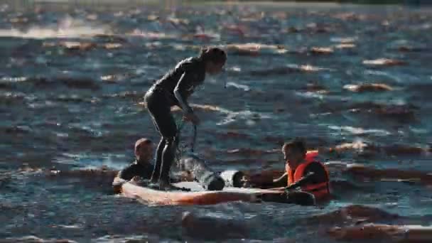 SAN PETERSBURG, RUSIA - 28 de agosto de 2016: Mujer en una tabla de surf tratando de encontrar el equilibrio, pero cae al agua — Vídeo de stock