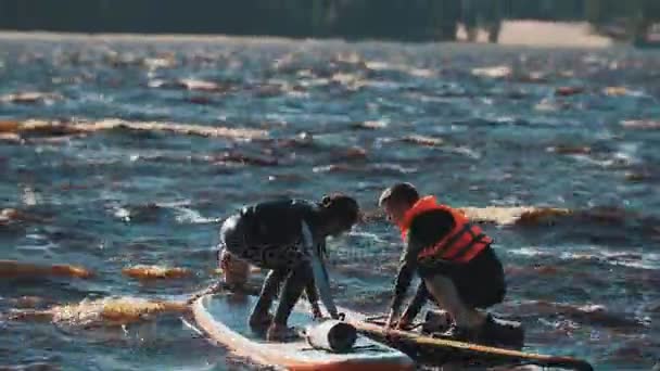 SAINT PETERSBURG, RUSSIA - 28 AGOSTO 2016: I surfisti si spingono a vicenda dalla tavola da surf in acqua, uno di loro cade — Video Stock