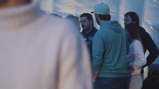 SAN PETERSBURG, RUSIA - 28 DE AGOSTO DE 2016: Grupo de jóvenes conversan y toman una copa dentro de una carpa. Luces coloridas — Vídeos de Stock