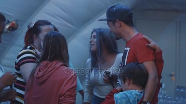 SAINT PETERSBURG, RUSSIE - 28 AOÛT 2016 : Un groupe de jeunes parle et rit à l'intérieur d'une tente. Femme fume narguilé — Video