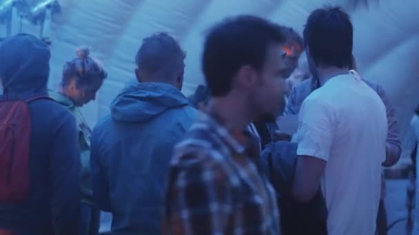 Sint-Petersburg, Rusland - 28 augustus 2016: Man in zonnebrillen en hoodie met usa vlag patroon gesprekken aan vriend binnen menigte — Stockvideo