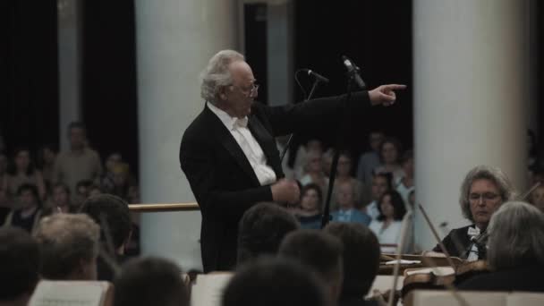 Sankt Petersburg, Ryssland - 23 juni 2016: Silver-haired kapellmeister rikta violin orkester i klassisk musik hall — Stockvideo