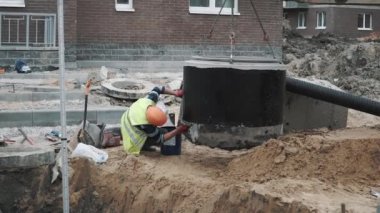 Saint Petersburg, Rusya - 26 Eylül 2016: İşçi çalışırken iğ altındaki beton kuyu yüzük, zincirleri üzerinde asılı