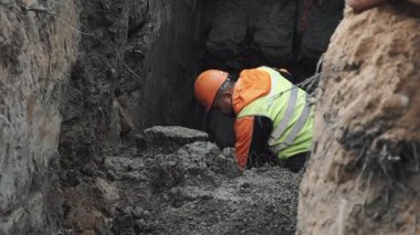 Saint Petersburg, Rusya - 26 Eylül 2016: Alt site oluşturma, kürek ile toprakta hendek kazma turuncu kask içinde